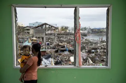 A victim from super typhoon Haiyan holds her daughter in Tacloban